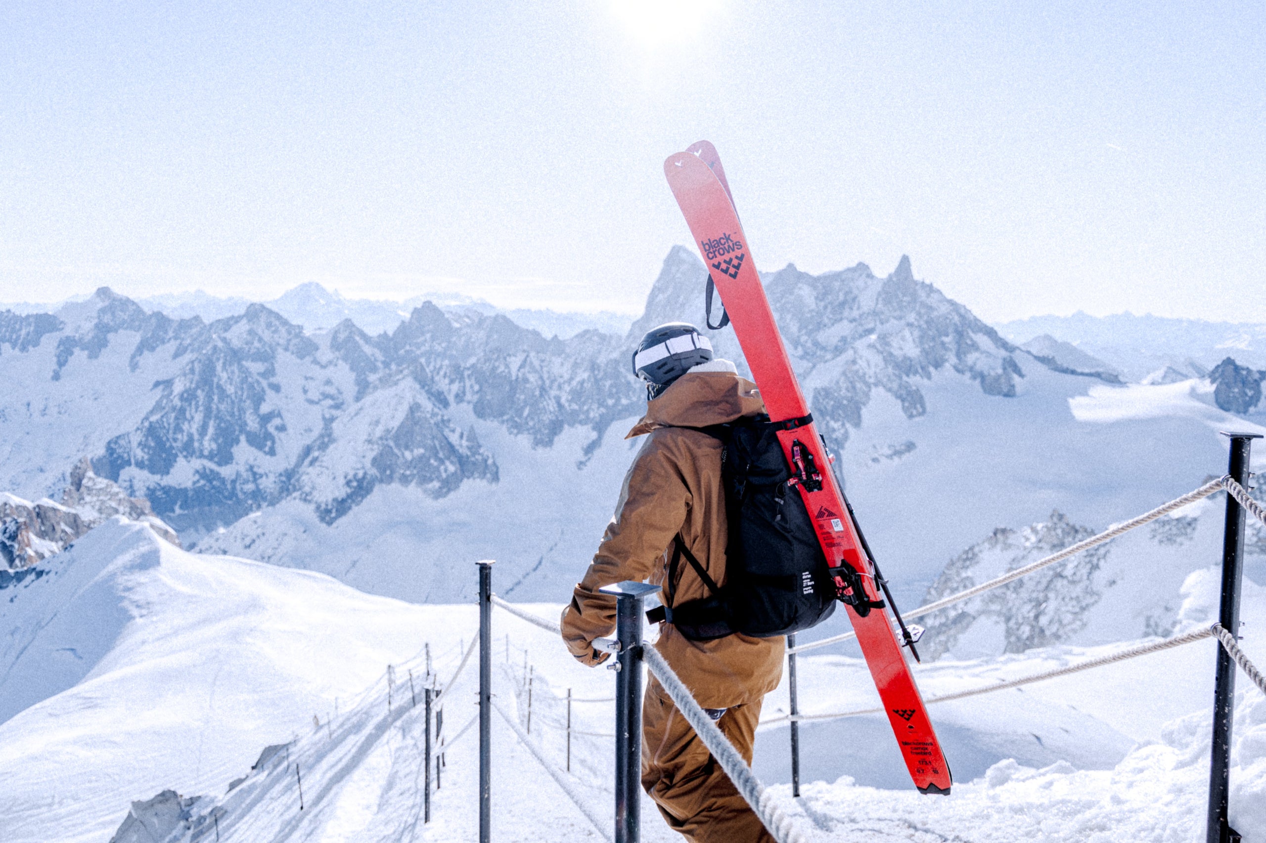 Freerider am Grat der Aiguille du Midi mit rotem Black Crows Freebird auf dem Rücken, Mont-Blanc-Massiv im Hintergrund